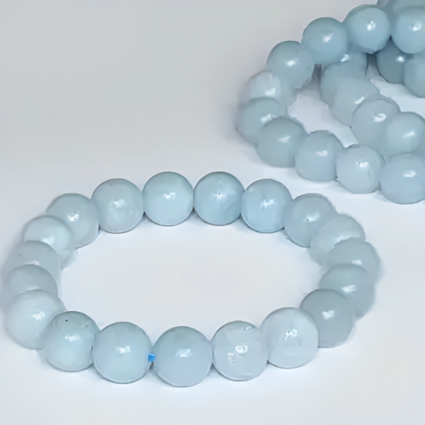 A bracelet made with milky blue aquamarine beads on a white background.